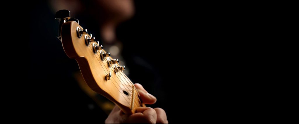 a child playing a guitar at their music tuition - music education needs digital transformation